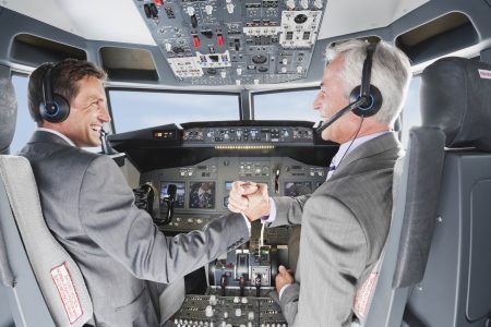 Germany, Bavaria, Munich, Businessmen piloting aeroplane from airplane cockpit